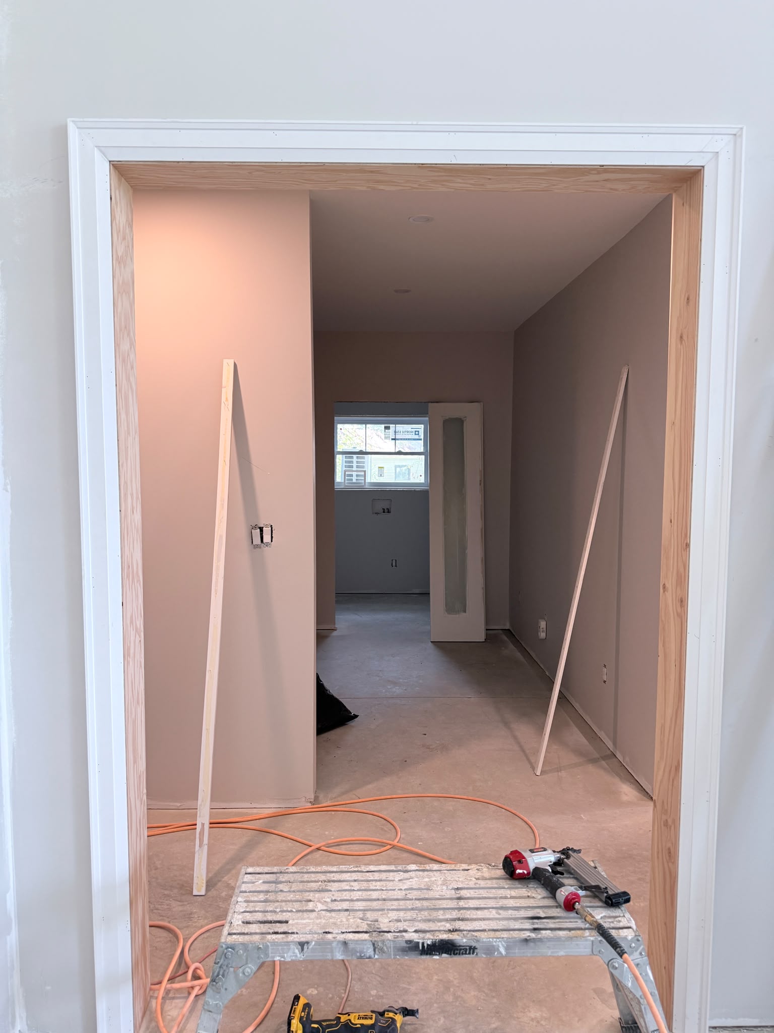 Wide interior doorway framed with newly installed white casing