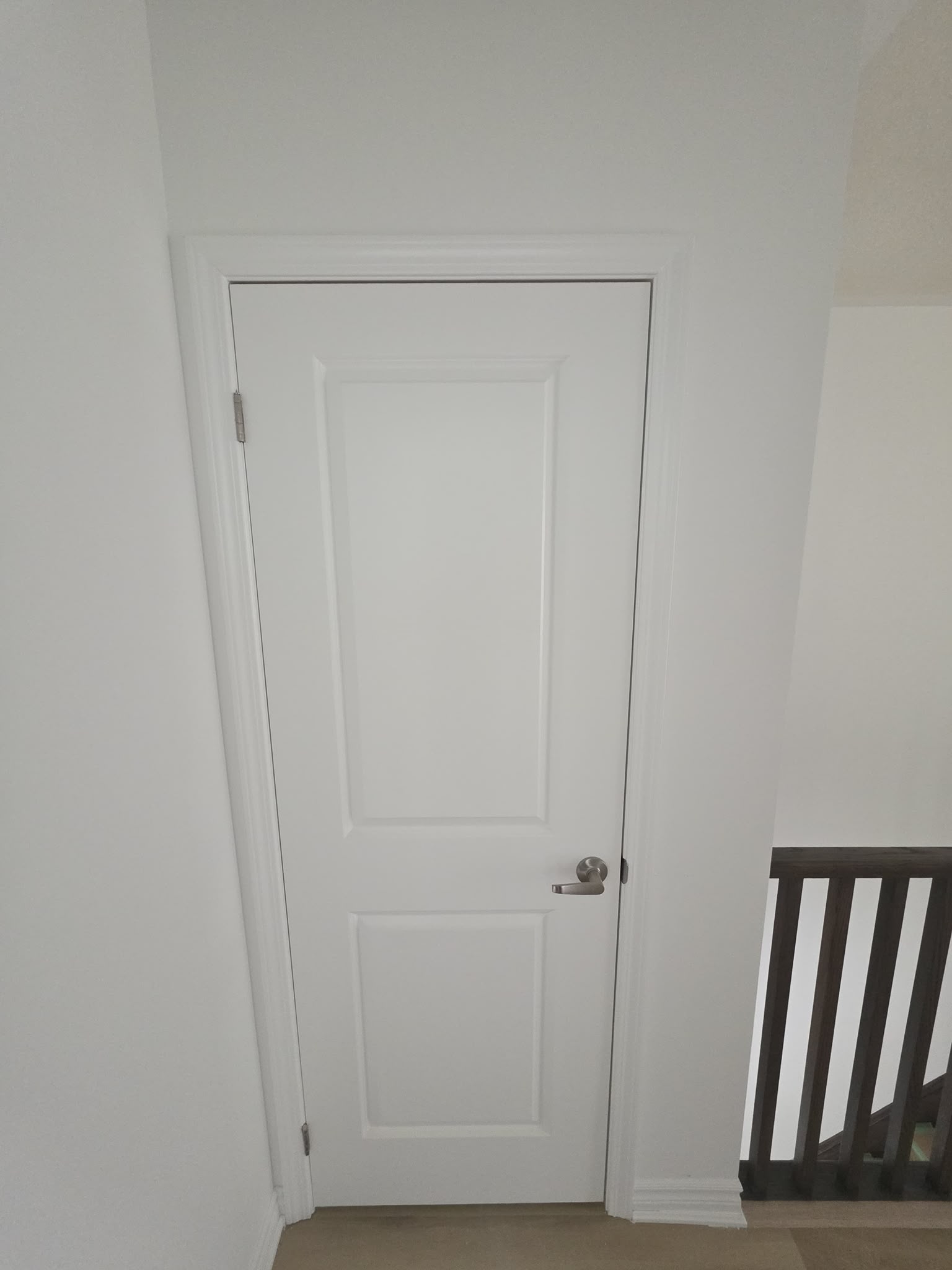 White panel door installed beside a stair landing